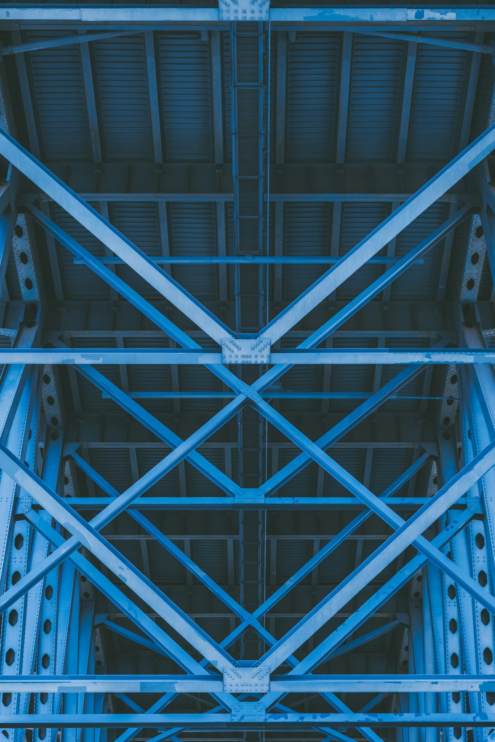 Low-angle view of steel beams and a metal roof structure in modern industrial construction.