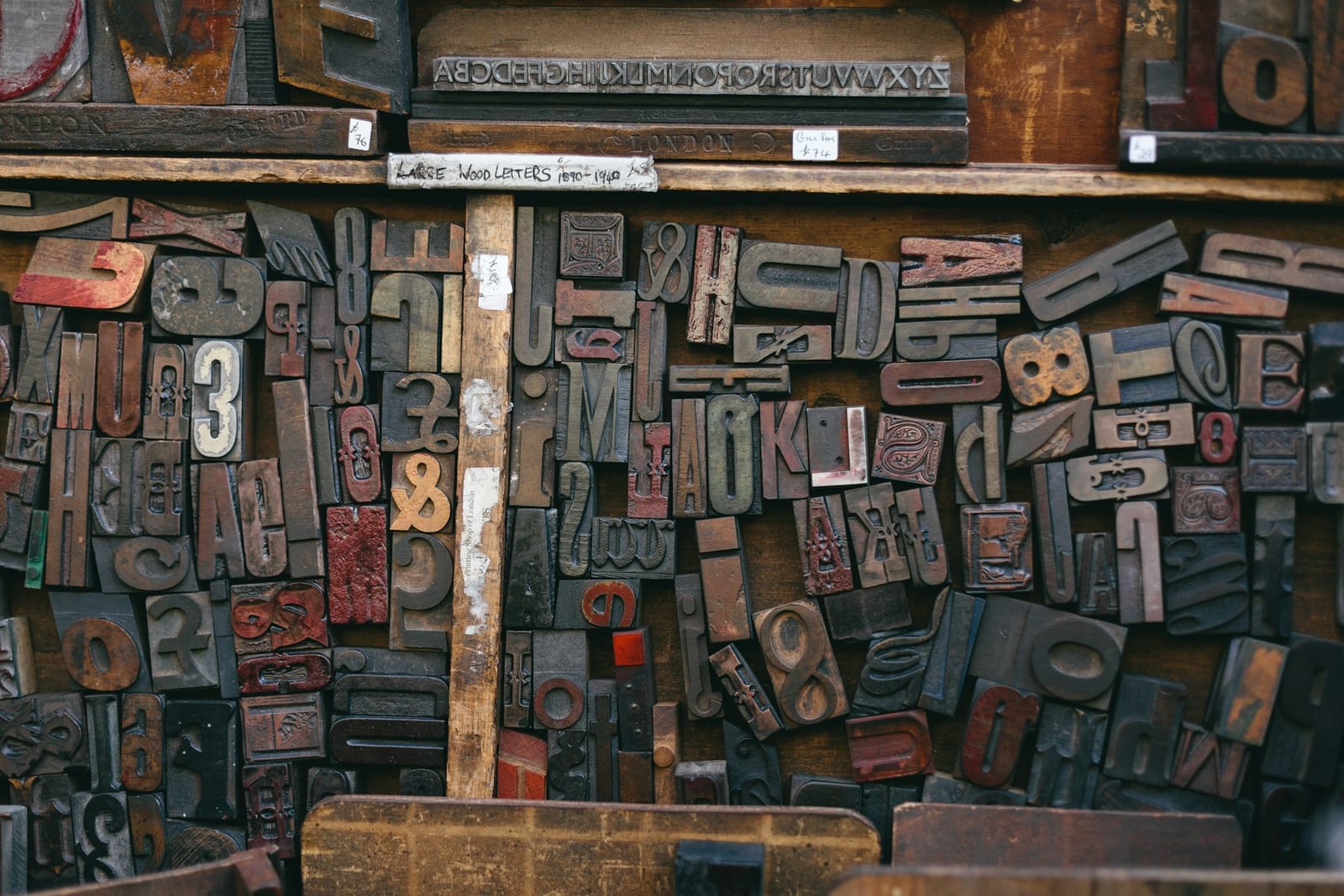 Close-up of assorted wood letterpress stamps arranged in a tray.